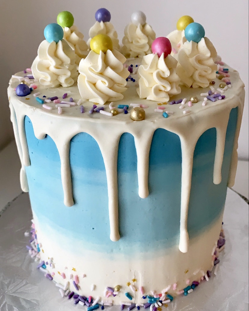 Image of a blue ombre cake with white choco drip.